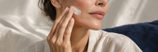 Application d’une crème sur la joue dans un rituel de soin du visage